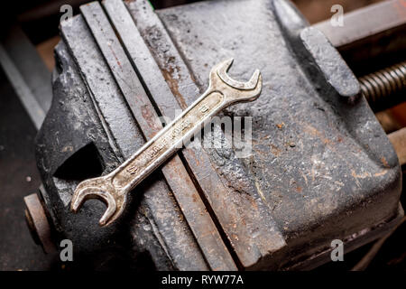 Vecchia chiave vintage su un grosso ferro vice isolato Foto Stock