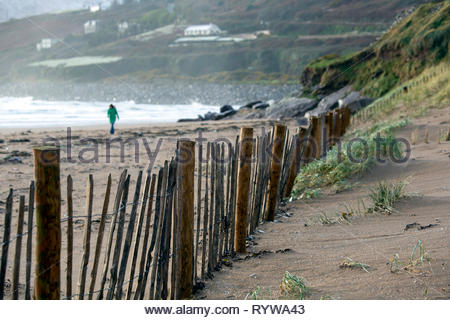 Una donna va a piedi lungo la spiaggia di Inich in Kerry parte del selvaggio modo atlantico Foto Stock