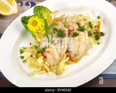 Cuocere i filetti di branzino su asparagi bianchi Foto Stock