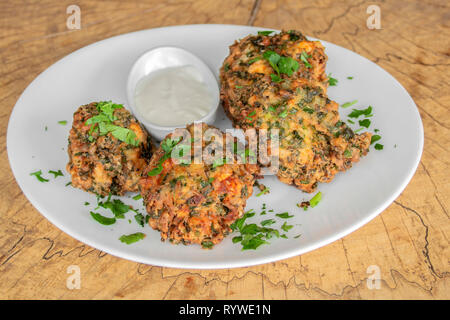 Polpette vegetariane. Con Spinaci, zucchine, prezzemolo. Panoramiche con il pangrattato. Guarnito con salsa di aglio. Foto Stock