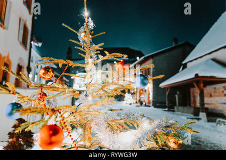 Natale abete nella strada della città medievale di Gruyeres, distretto di Gruyere, Canton Friburgo in Svizzera Foto Stock