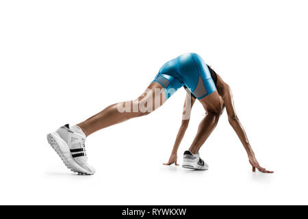 Giovane donna africana la preparazione a inizio corsa isolato su bianco di sfondo per studio. Una femmina runner o pareggiatore. Silhouette di jogging atleta. Foto Stock