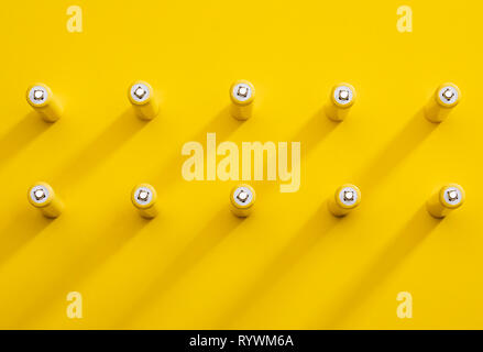 Vista superiore giallo batterie alcaline AAA colorato pop art stile lay piatto modello foto Foto Stock