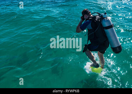 Maschio sub con attrezzatura salta in acqua Foto Stock