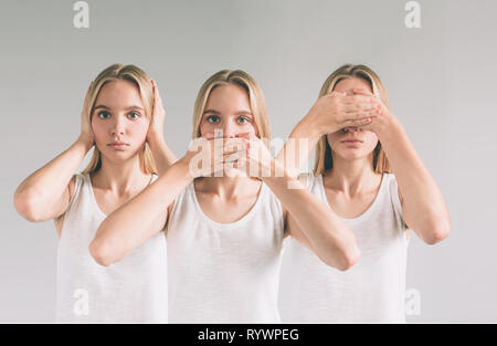 Isolato studio shot di una donna caucasica nel vedere alcun male, non sento, non parlo pone Foto Stock