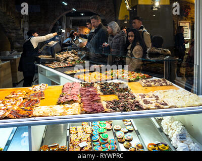 BERGAMO, Italia - 25 febbraio 2019: vista attraverso la finestra di strada con locale fast food della gente in Bakery Cafe acquistare panini per pranzo in Bergamo alta. Foto Stock