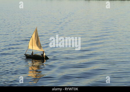 Due uomini su una piccola vela powered pesca in barca sul fiume Nilo vicino al tramonto, Egitto, Nord Africa e Medio Oriente Foto Stock