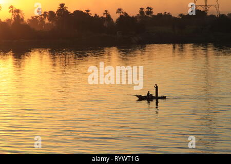 Due uomini la pesca da una piccola barca sul Nilo al tramonto, Egitto, Nord Africa e Medio Oriente Foto Stock