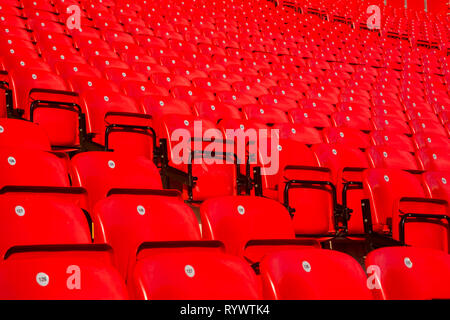 Righe di numerati lucido pieghevole in plastica rosso posti a sedere per i tifosi sulle terrazze del cavalletto principale a Liverpool Football Club di Anfield Road Stadium, LANCASHIRE REGNO UNITO. Foto Stock