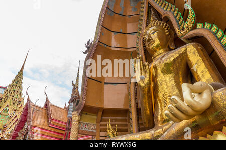 Grande golden Buddha, seduti al tempio con la mano alzata Foto Stock