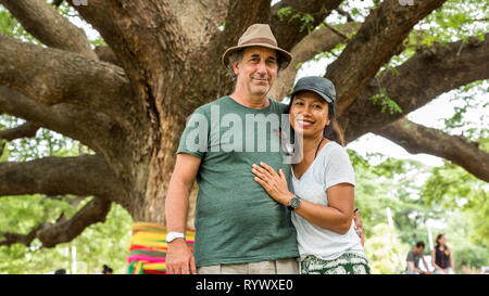 Il marito e la moglie sotto il Thai Monkeypod albero in Kanchanaburi Thailandia Foto Stock