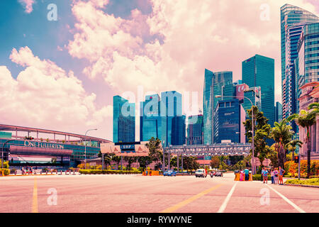 Singapore, Singapore - 1 Marzo 2016: grattacieli in Fullerton Road a Singapore. Edifici alti sullo sfondo. I turisti in strada Foto Stock