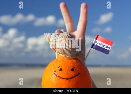Frutta di arancia e Paesi Bassi mini bandiera con testo: KONINGSDAG - Kings giorno. Foto Stock