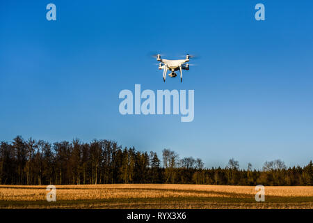 DJI Phantom 4 PRO quadcopter drone in aria volando al di sopra di un campo, Germania Foto Stock