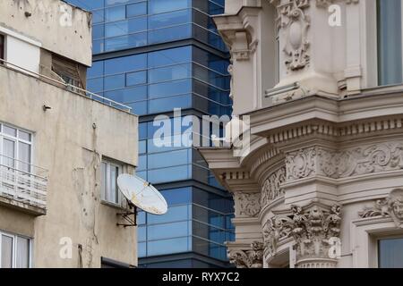 Bucarest, Romania - Febbraio 07, 2019: un alto e moderno edificio in contrasto con alcuni edifici vecchi e Grand Hotel Continental (R) situato sulla Victo Foto Stock