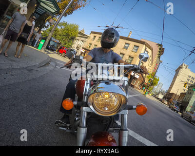 Il centro di Vancouver, British Columbia, Canada - 16 Giugno 2018: uomo su un motociclo è in sella a una città moderna durante una soleggiata giornata estiva. Foto Stock