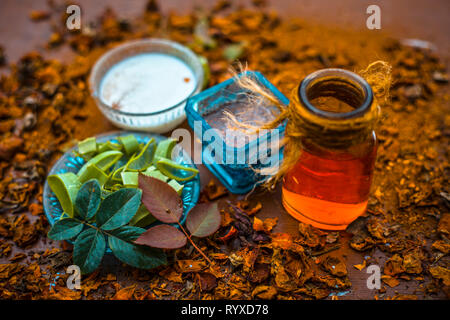 Close up Aloevera con legno di sandalo in polvere e latte con acqua di rose su una superficie di legno per l'acne libera la pelle. Foto Stock