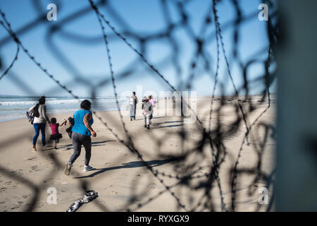 Tijuana, Baja Mexico, Messico. 13 Mar, 2019. Dopo aver infilato attraverso un piccolo foro nel muro di confine dividendo gli Stati Uniti e il Messico, richiedenti asilo sul suolo americano. Mentre alcune persone sono state catturate, pattuglia di confine è stato travolto dalla massa di attraversamento del gruppo e non sono stati in grado di arrestare tutti inizialmente. Nel febbraio 2019, circa 76.000 sono fuggiti dal sud del confine con gli Stati Uniti al fine di trovare una migliore live. Credito: Megan Jelinger SOPA/images/ZUMA filo/Alamy Live News Foto Stock