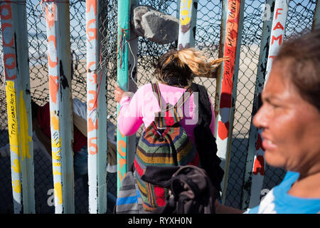 Tijuana, Baja California, Messico. 13 Mar, 2019. Le famiglie sono visti scivolare attraverso gli Stati Uniti - Messico - recinzione di confine in sforzi per chiedere asilo negli Stati Uniti. Nel febbraio 2019, circa 76.000 sono fuggiti dal sud del confine con gli Stati Uniti al fine di trovare una migliore live. Credito: Megan Jelinger SOPA/images/ZUMA filo/Alamy Live News Foto Stock