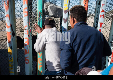 Tijuana, Baja California, Messico. 13 Mar, 2019. Le famiglie sono visti scivolare attraverso gli Stati Uniti - Messico - recinzione di confine in sforzi per chiedere asilo negli Stati Uniti. Nel febbraio 2019, circa 76.000 sono fuggiti dal sud del confine con gli Stati Uniti al fine di trovare una migliore live. Credito: Megan Jelinger SOPA/images/ZUMA filo/Alamy Live News Foto Stock