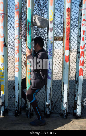 Tijuana, Baja California, Messico. 13 Mar, 2019. Un giovane uomo è visto scivolare attraverso gli Stati Uniti - Messico frontiera in sforzi per chiedere asilo negli Stati Uniti. Nel febbraio 2019, circa 76.000 sono fuggiti dal sud del confine con gli Stati Uniti al fine di trovare una migliore live. Credito: Megan Jelinger SOPA/images/ZUMA filo/Alamy Live News Foto Stock