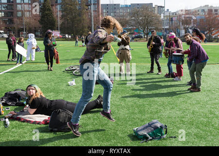 Seattle, Washington: una giovane donna danze come una banda di ottoni riproduce in un rally in Cal Anderson Park a sostegno del New Deal Verde e per attirare l'attenzione sulla mancanza di azione sul cambiamento climatico. La Gioventù di Seattle clima sciopero era stato tenuto in è la solidarietà con il clima mondiale movimento di sciopero. Credito: Paolo Christian Gordon/Alamy Live News Foto Stock