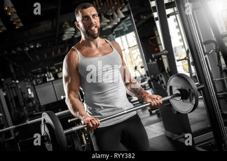 Bodybuilding. Uomo Barbuto in piedi in palestra sollevando barbell motivati Foto Stock