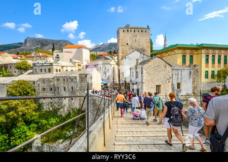 Una folla di turisti attraversare il restaurato ponte di Mostar nella città di Mostar, Bosnia, mentre si fanno strada nella città vecchia sezione. Foto Stock