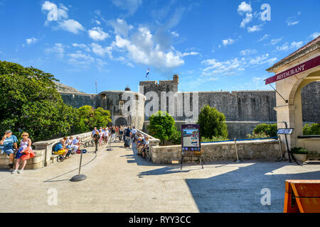 La città esterna pila di gate e il ponte di pietra che portano alle antiche mura della città di Dubrovnik, Croazia con turisti che si godono una soleggiata giornata estiva Foto Stock