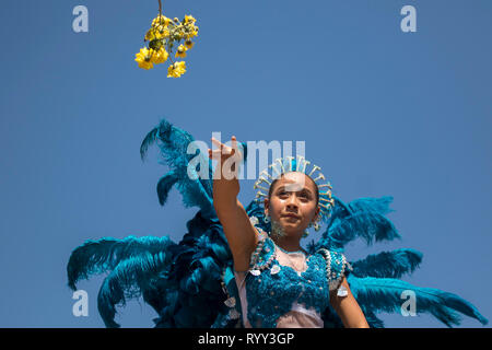 Bambina gettando fiori alla folla. La battaglia dei fiori è un evento che si svolge il sabato del carnevale. Si tratta di una sfilata di carri allegorici, compa Foto Stock