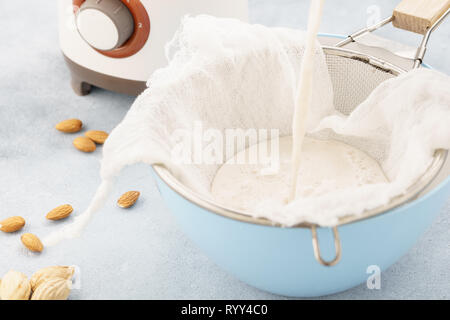 In casa il dado latte rendendo processo. Versare il latte in un panno. Ricetta Step by step. Foto Stock