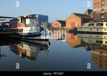 Viaggio turistico barche ormeggiate in Gloucester Docks brigt nella luce solare e acqua calma con riflessioni Foto Stock