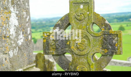 Il muschio verde sulla croce stonehenge nel cimitero al di fuori della Rocca di Cashel in Irlanda Foto Stock