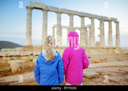 Due giovani sorelle ad esplorare il Greco antico tempio di Poseidone a Capo Sounion, uno dei principali monumenti di età d'Oro di Atene. Foto Stock