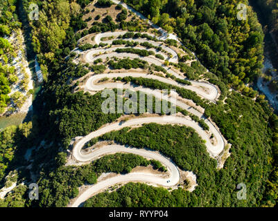 Antenna vista dall'alto in basso di serpeggiante strada stretta che conduce a Vikos nella Grecia settentrionale. Una strada piena di colpi di scena e svolte avvolgimento bruscamente fino al monte Foto Stock