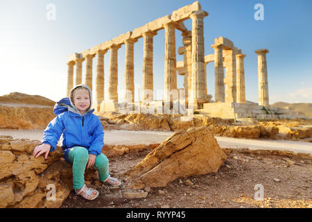 Carino giovane ragazza ad esplorare il Greco antico tempio di Poseidone a Capo Sounion, uno dei principali monumenti di età d'Oro di Atene. Foto Stock