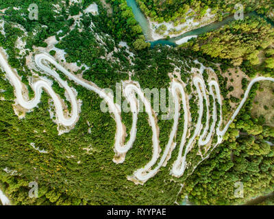 Antenna vista dall'alto in basso di serpeggiante strada stretta che conduce a Vikos nella Grecia settentrionale. Una strada piena di colpi di scena e svolte avvolgimento bruscamente fino al monte Foto Stock