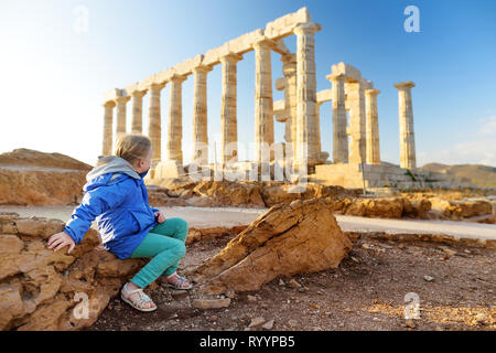 Carino giovane ragazza ad esplorare il Greco antico tempio di Poseidone a Capo Sounion, uno dei principali monumenti di età d'Oro di Atene. Foto Stock