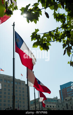 Bandiere cilena onda in Plaza de la Constitución, o Piazza della Costituzione, nel centro storico di Santiago del Cile. Foto Stock