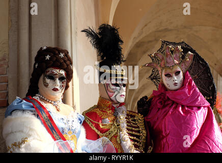 Trio vestito nel tradizionale maschera e costume per il Carnevale di Venezia  in piedi sotto arcate al palazzo ducale di Piazza San Marco, Venezia, Veneto,  Italia Foto stock - Alamy