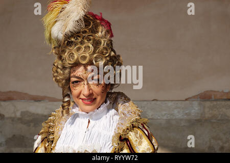 Donna in costume tradizionale per il Carnevale di Venezia in piedi al palazzo ducale di Piazza San Marco, Venezia, Veneto, Italia Foto Stock