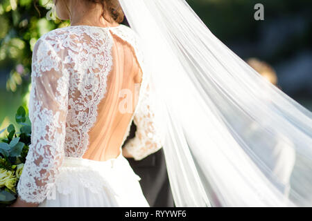 Sposa tenendo un bellissimo mazzo di nozze durante la bella cerimonia di nozze sulla soleggiata giornata estiva all'aperto. Foto Stock