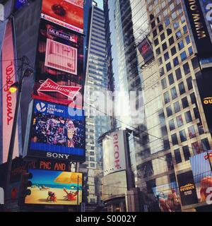 La luce del sole riflessioni e inserzioni in Times Square a New York City Foto Stock