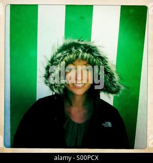 Una giovane donna si trova di fronte una verde e pareti bianche. L'Irlanda. Foto Stock