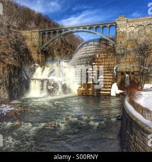 L'acqua scorre sul canale di scarico del nuovo Croton diga su una calda giornata invernale in Cortlandt, New York. Foto Stock