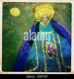 Un tappeto di sabbia con l'immagine della Vergine di Juquila decora un cimitero durante il giorno dei morti in festa a Oaxaca, Messico Foto Stock