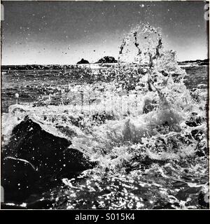 Immagine in bianco e nero di spruzzi d'acqua sulle rocce Foto Stock