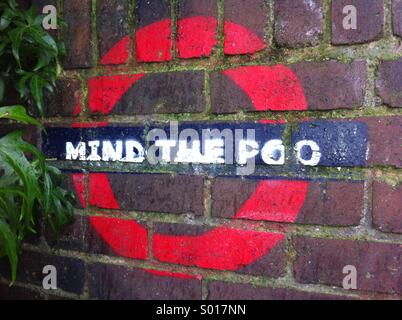 Graffiti Arte. La metropolitana di Londra simbolo dipinto sulla parete di un vicolo di via dicendo mente il poo. Foto Stock