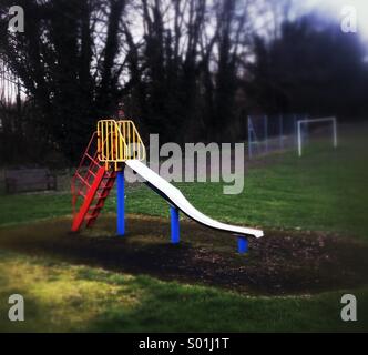 Per i bambini in diapositiva vuota parco giochi Foto Stock