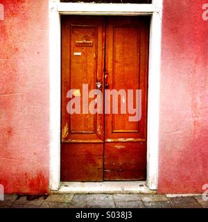 La porta di una casa rosa. Burano Italia. Foto Stock